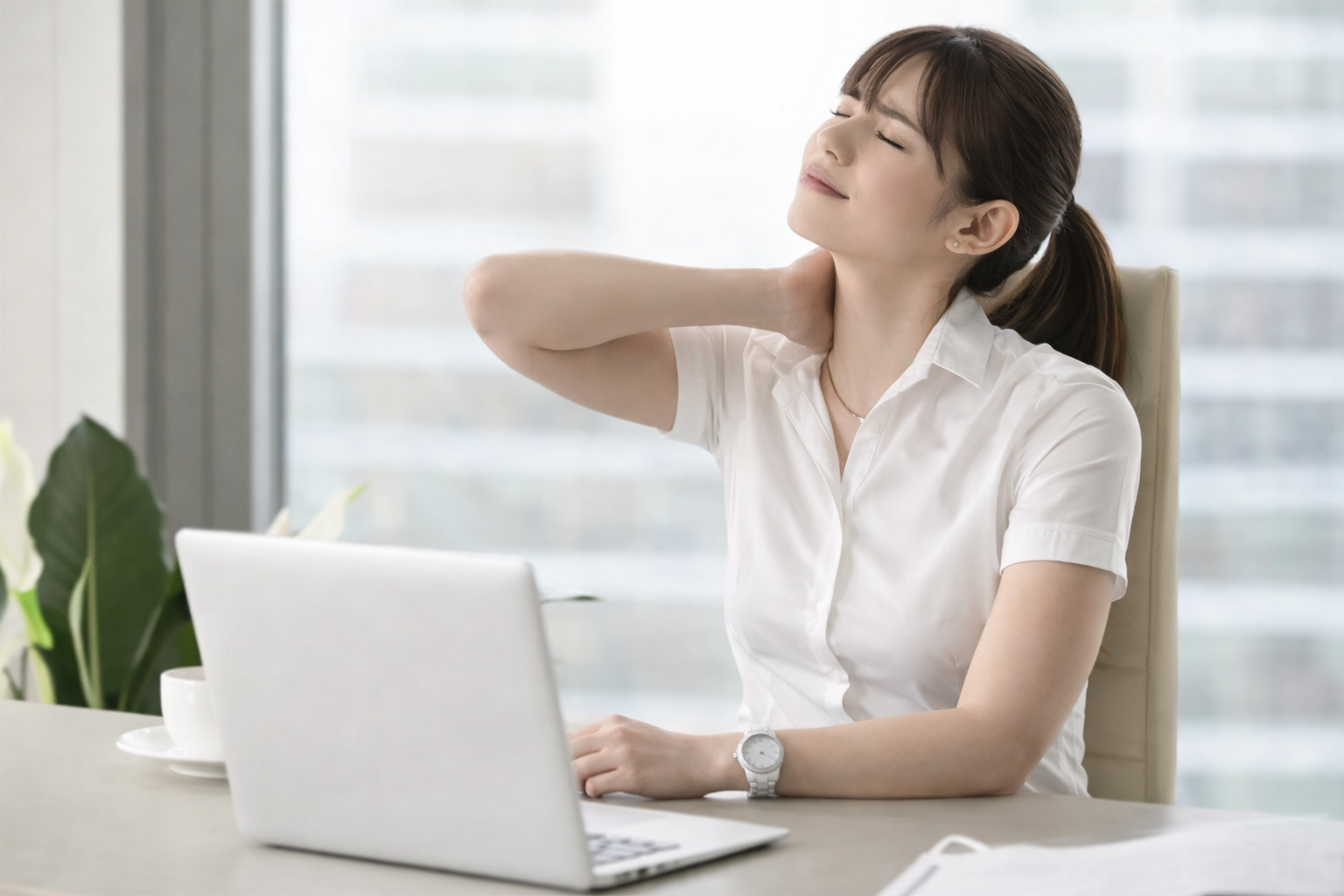 肩こりが続いてつらそうにしている女性のイメージ