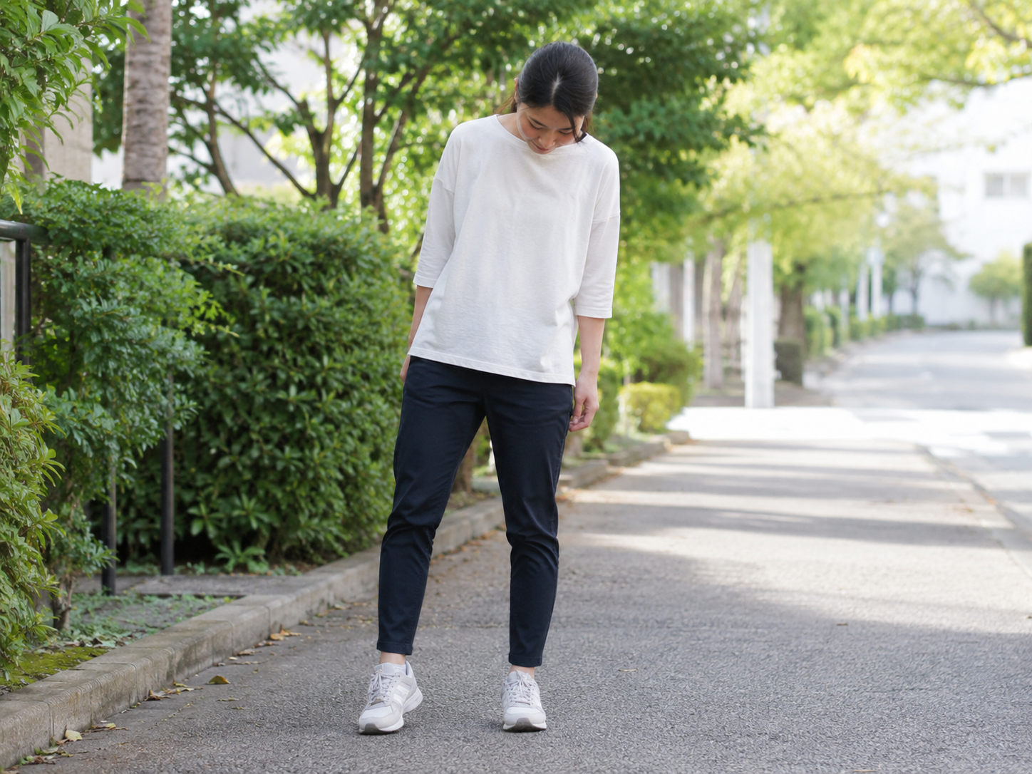 片側に体重をかけて立っている女性、または足元を確認している女性
