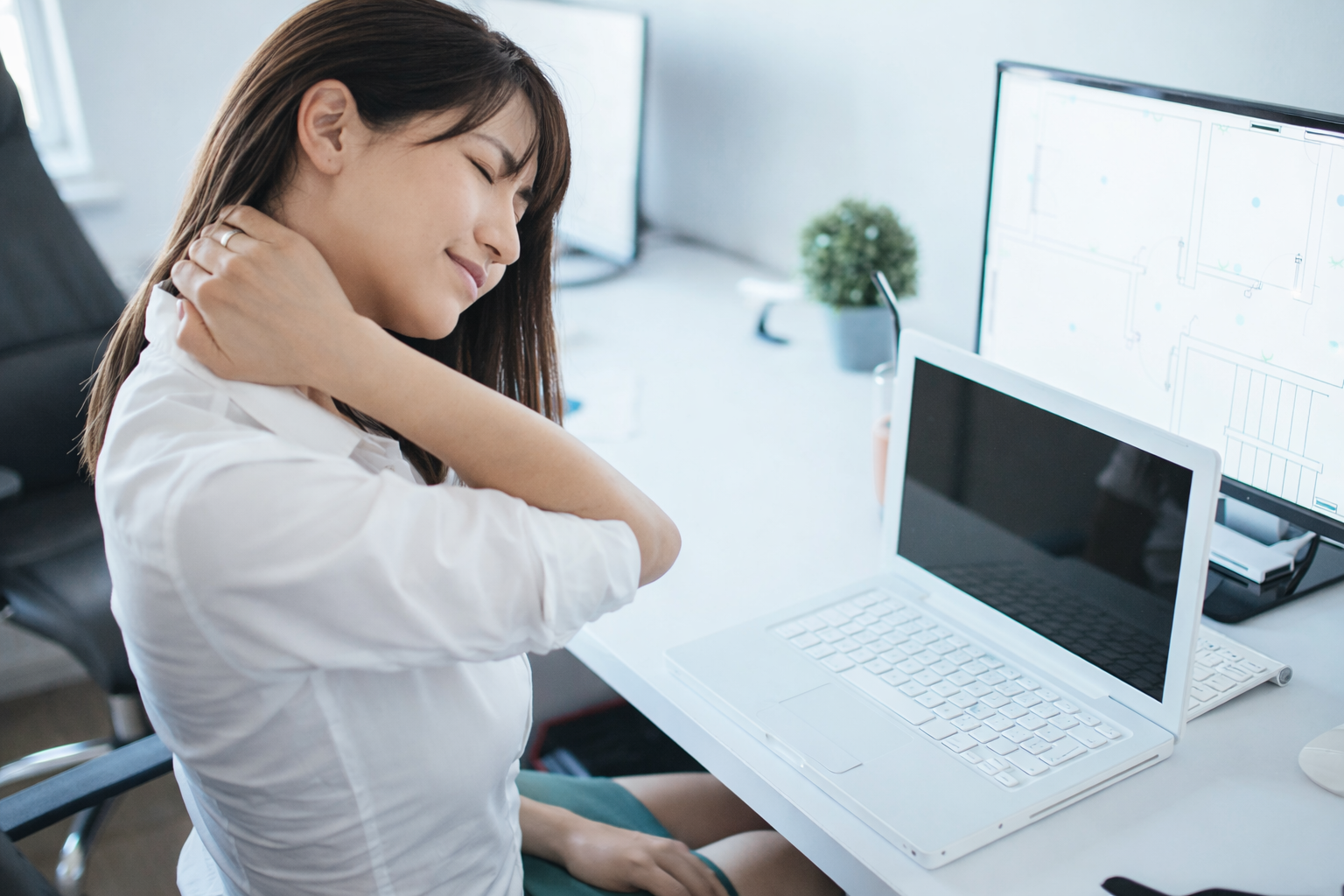 デスクワークで肩こりがつらい女性のイメージ