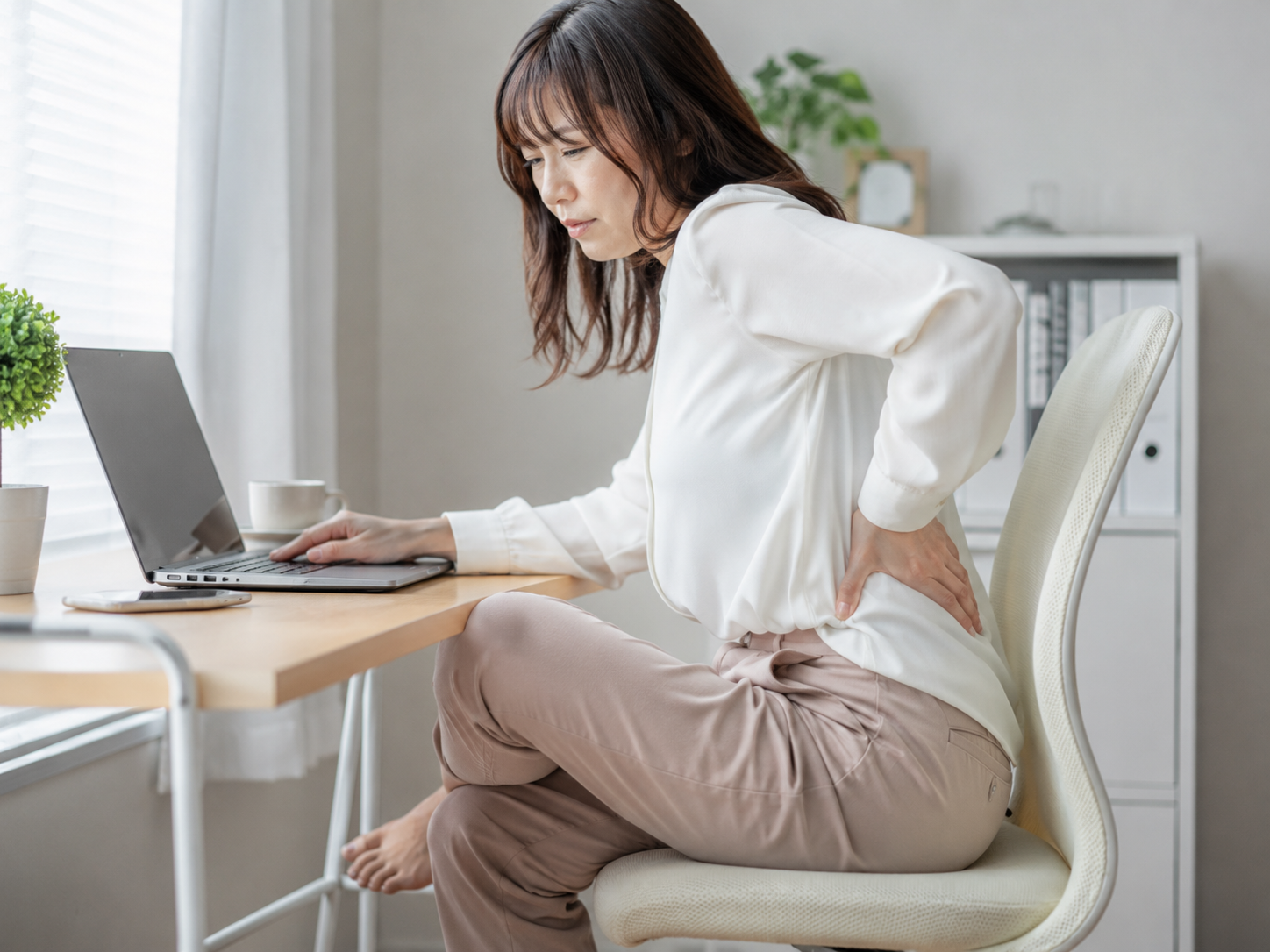 足を組む座り方が腰痛に関係することを説明するイメージ