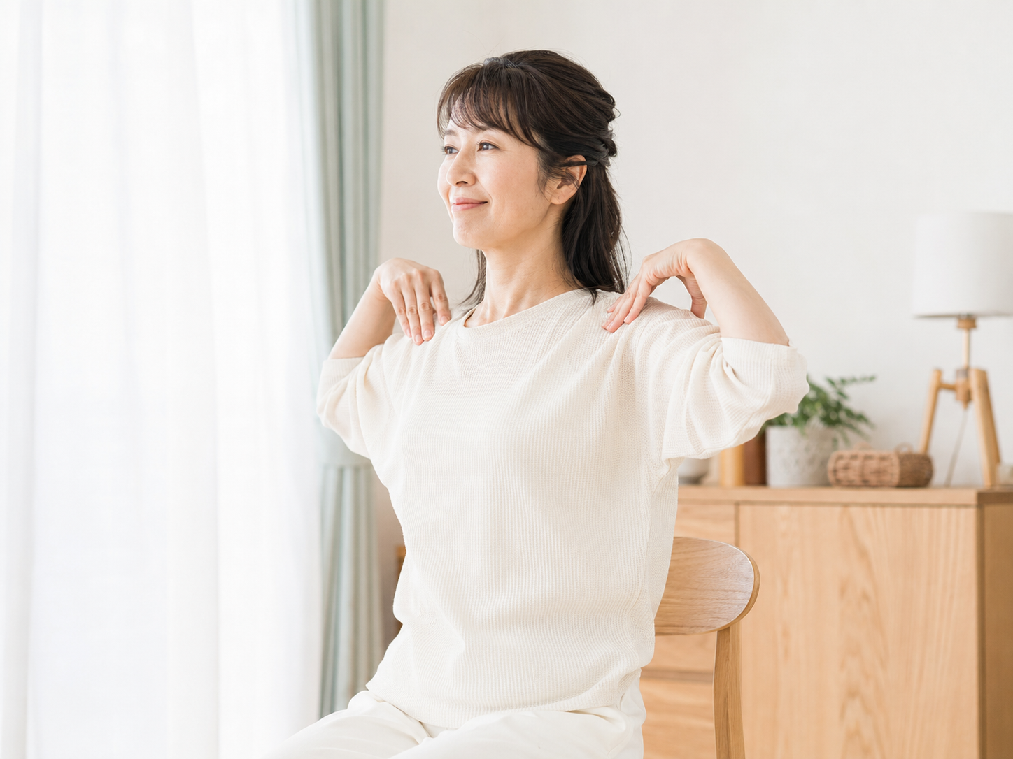 夕方の肩こり対策として室内でやさしく肩を回す女性