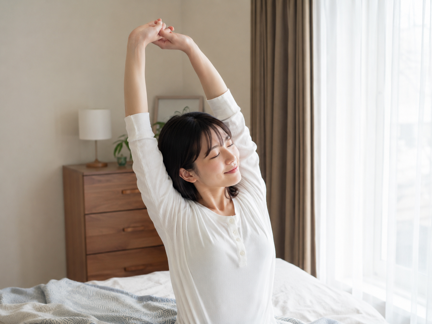 梅雨時期の体のだるさ対策として朝に背伸びをする女性