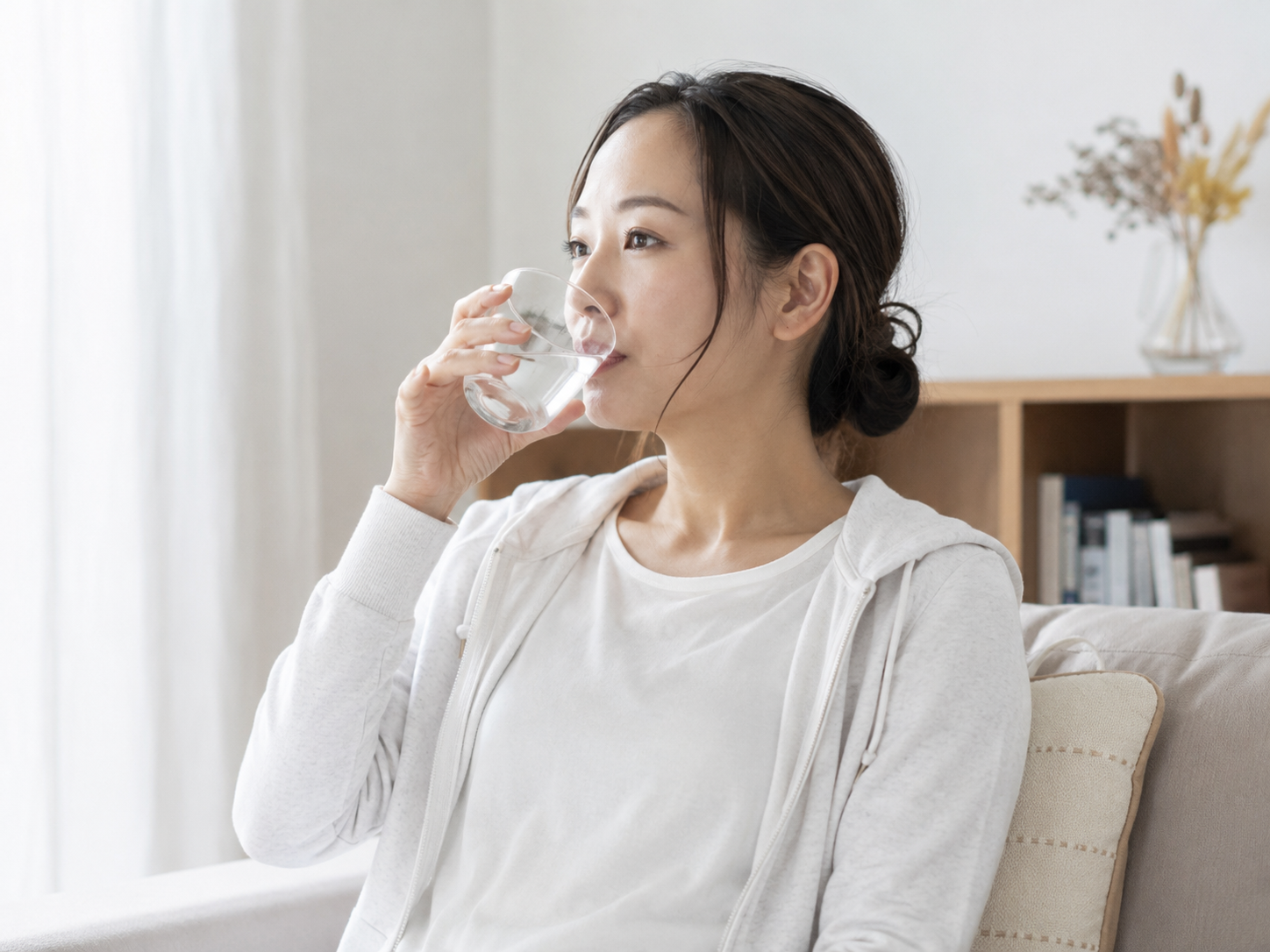 熱中症対策として室内で水分補給をしている女性