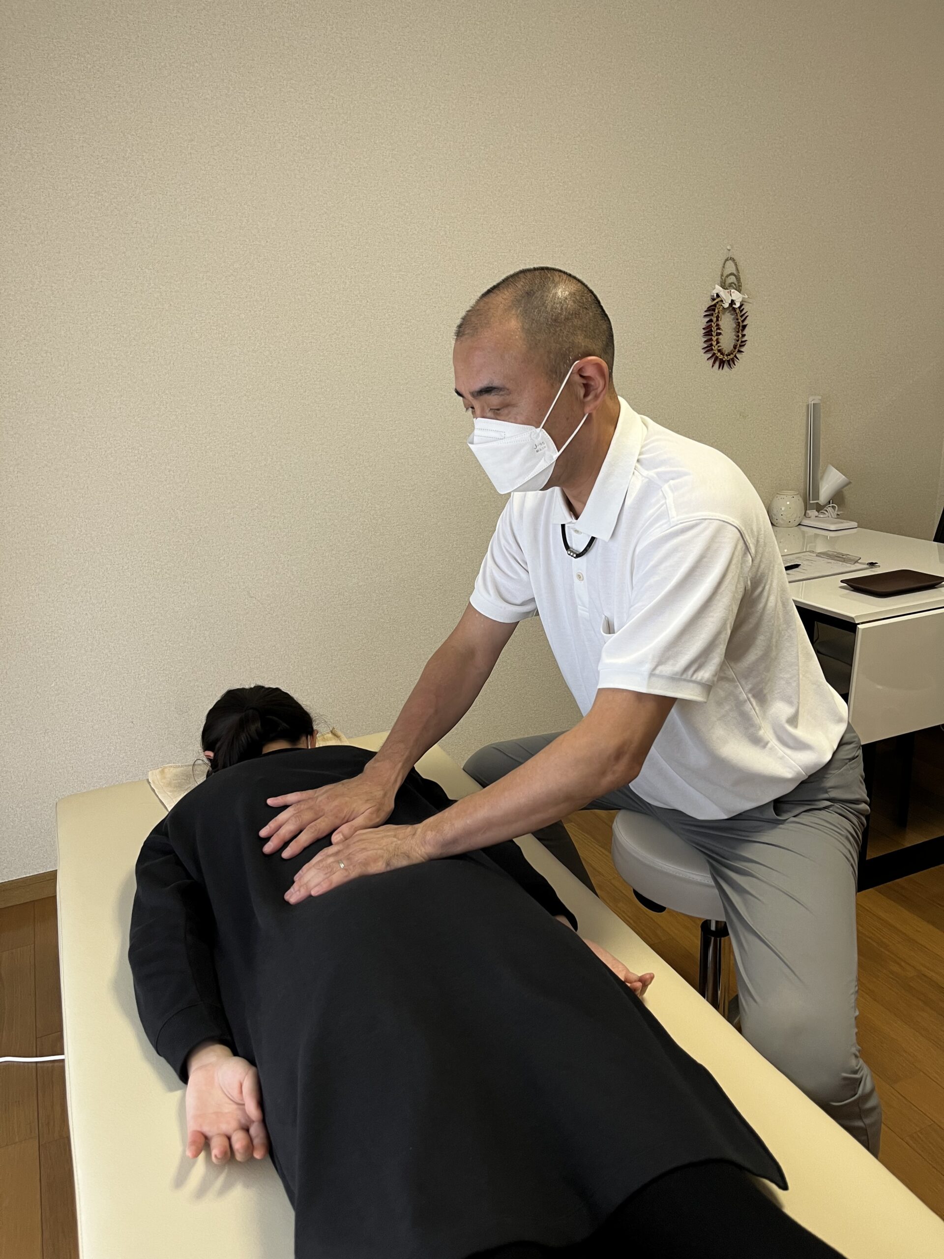 背中をやさしく調整する整体施術の様子