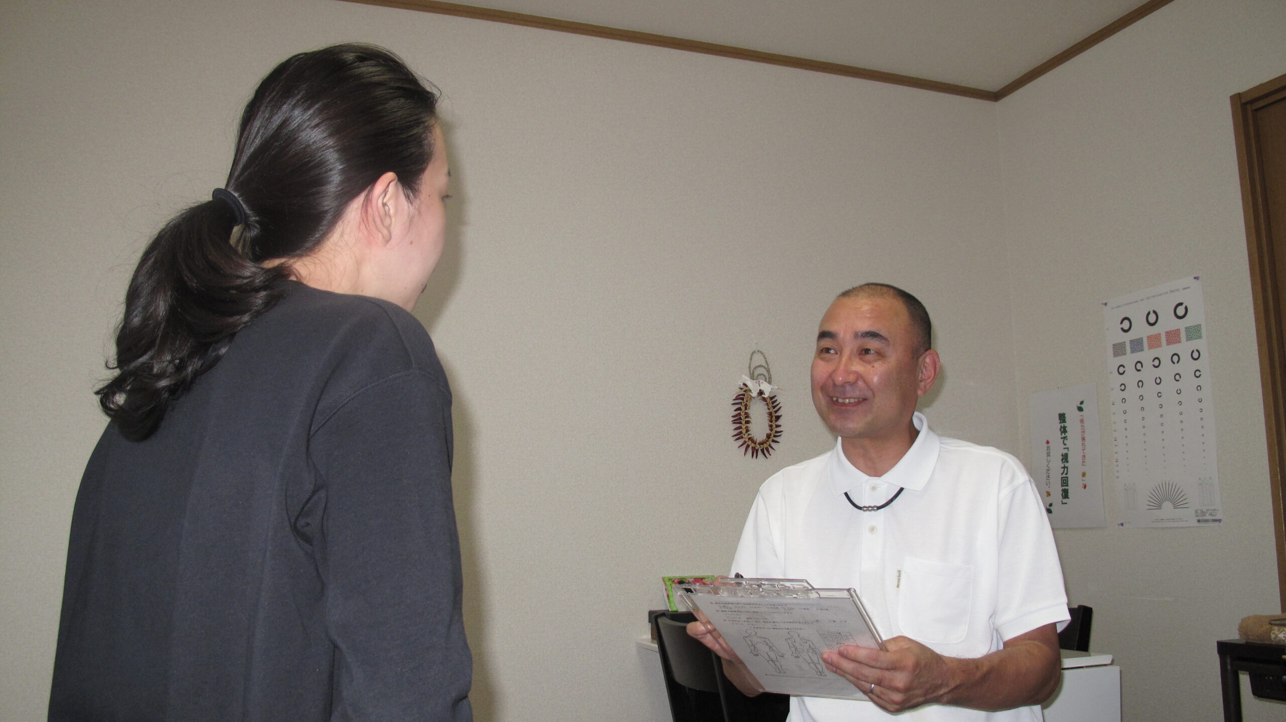 関節トレーニングの説明をしている写真です。