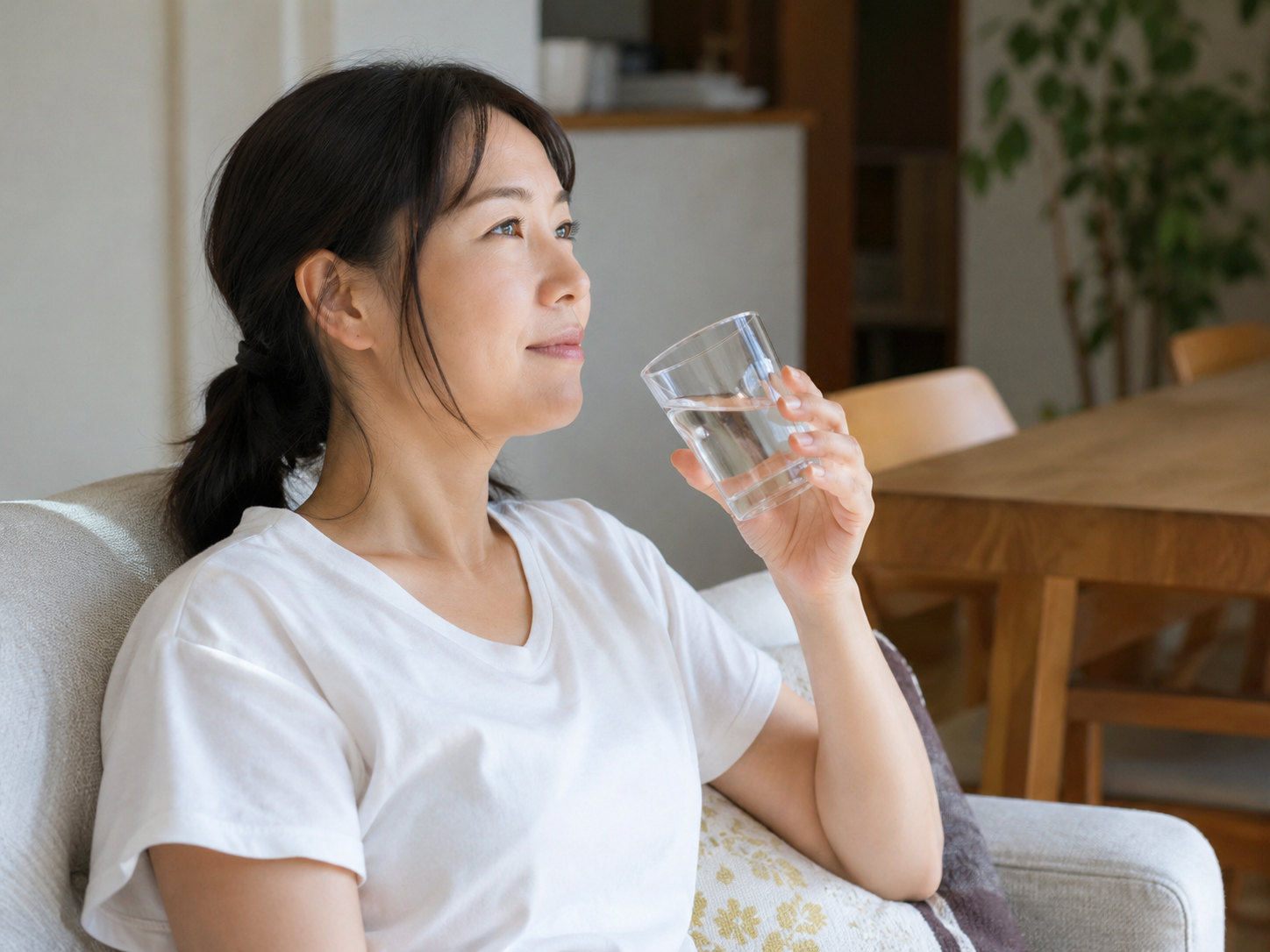 夏前の体調管理として室内で水分補給をする女性