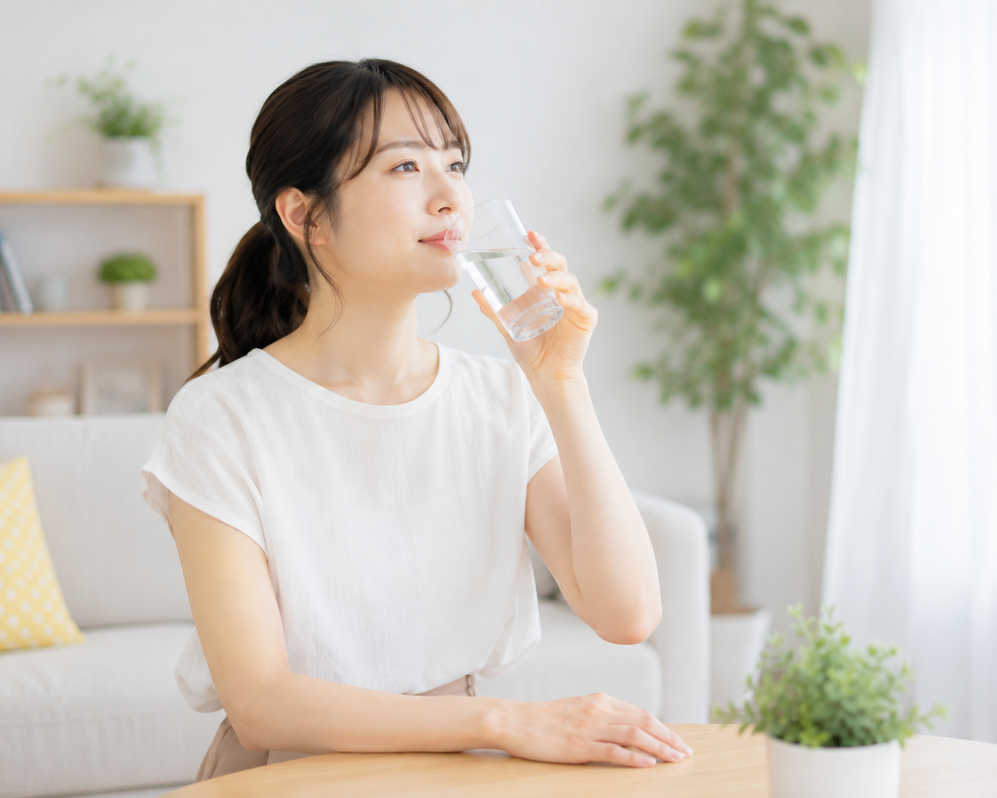 夏の体調管理として室内で水分補給をする女性