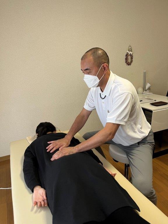 湘南山手整体院での施術の様子です。背中をやさしく揺らしています。