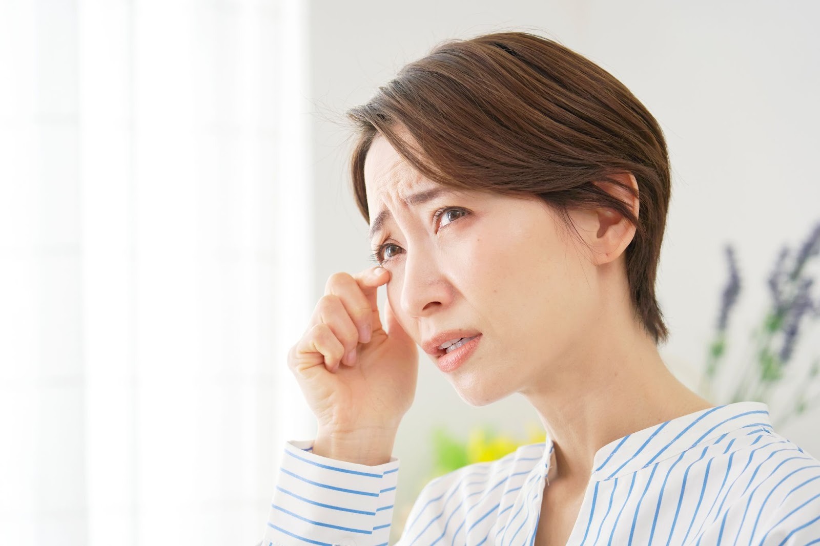 目の充血でつらい様子の女性