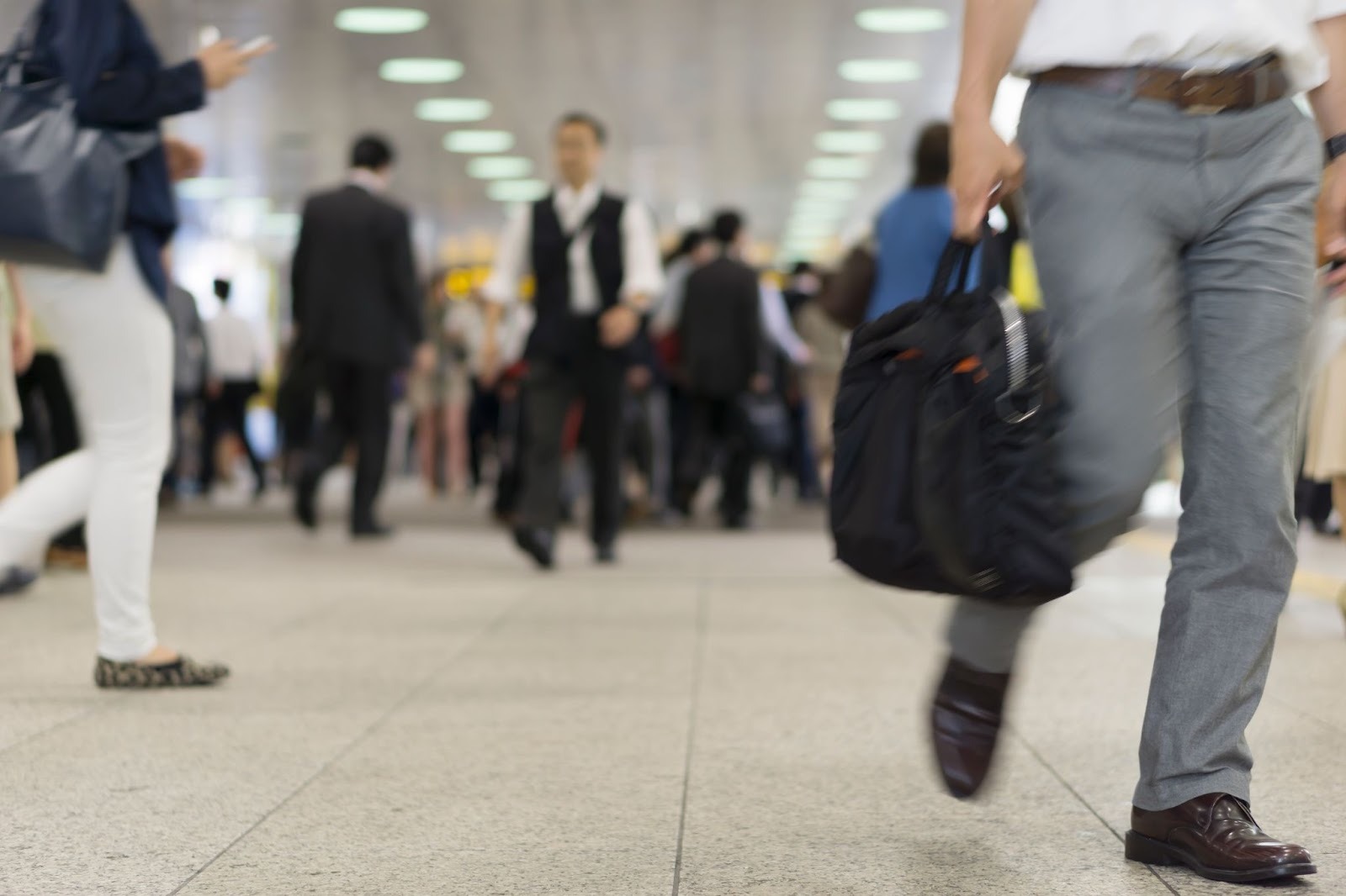 横須賀市内の駅。速足で通勤しているサラリーマンの様子