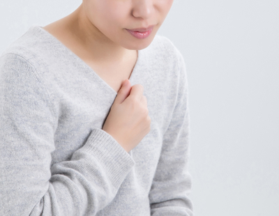 呼吸が浅く肩・首が緊張している女性の写真です。