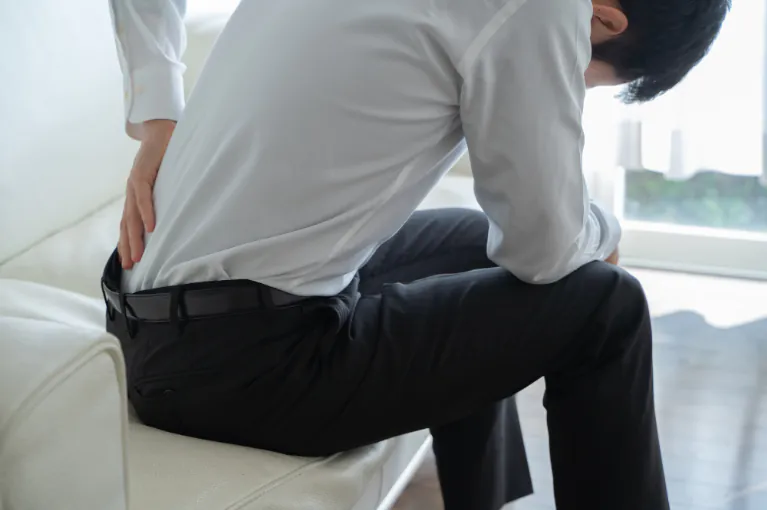 骨盤がゆがみ、腰の痛みを訴える男性の写真です。