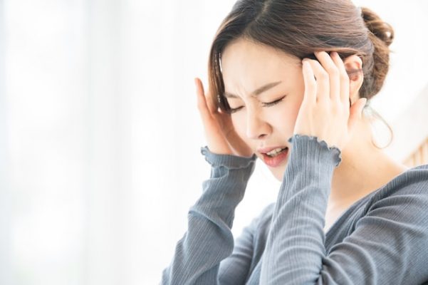 頭痛に悩まされている女性の写真です。
